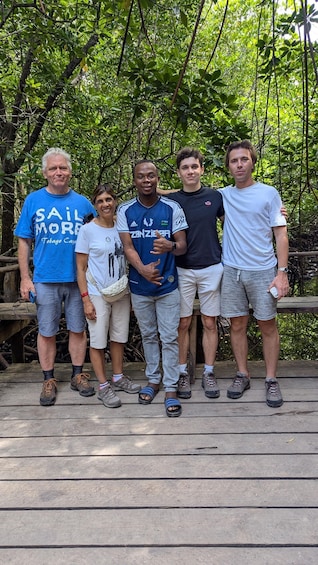 A group of people standing on a wooden platform in a forested area. 2