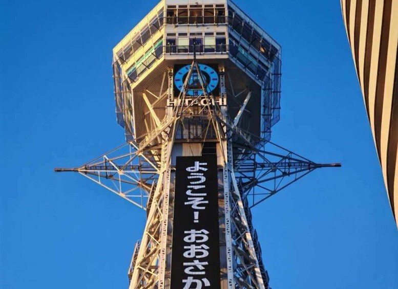 A tall tower with a clock and Japanese text. 4