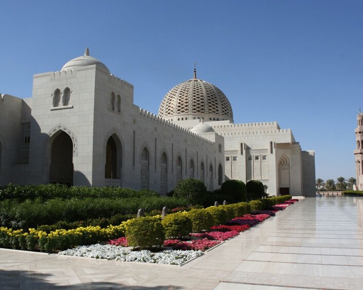 A large, white, domed building with arched windows and a long, tiled walkway. 5