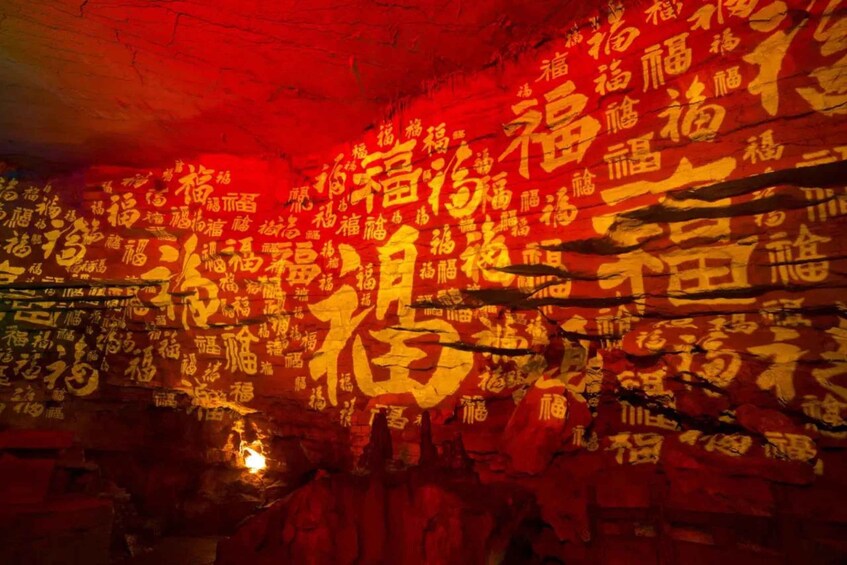 A cave wall covered with golden Chinese characters. 5