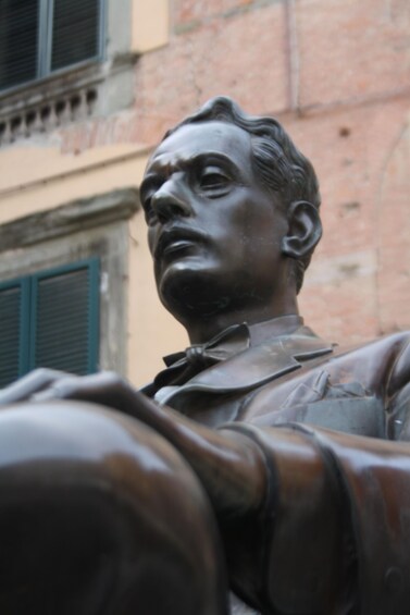 A bronze statue of a man with a bow tie. 2