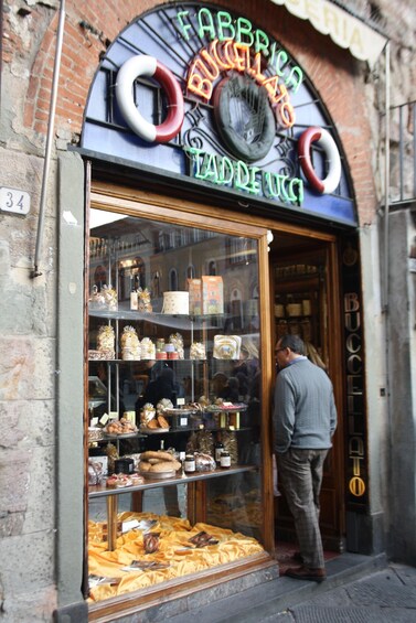 A bakery with a sign that reads "FABBRICA BUCCELLA" and displays various baked goods. 4