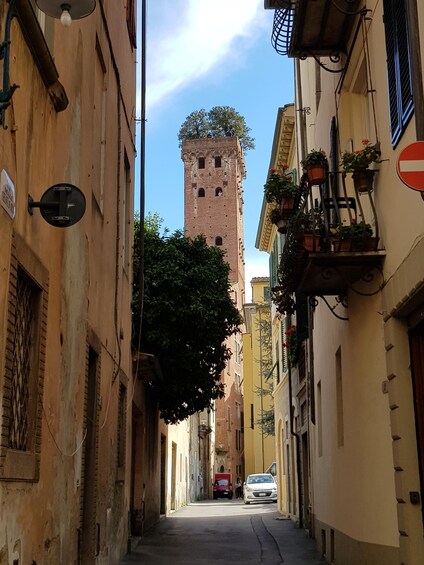 A narrow street with old buildings, a tower, and a 'no entry' sign. 3