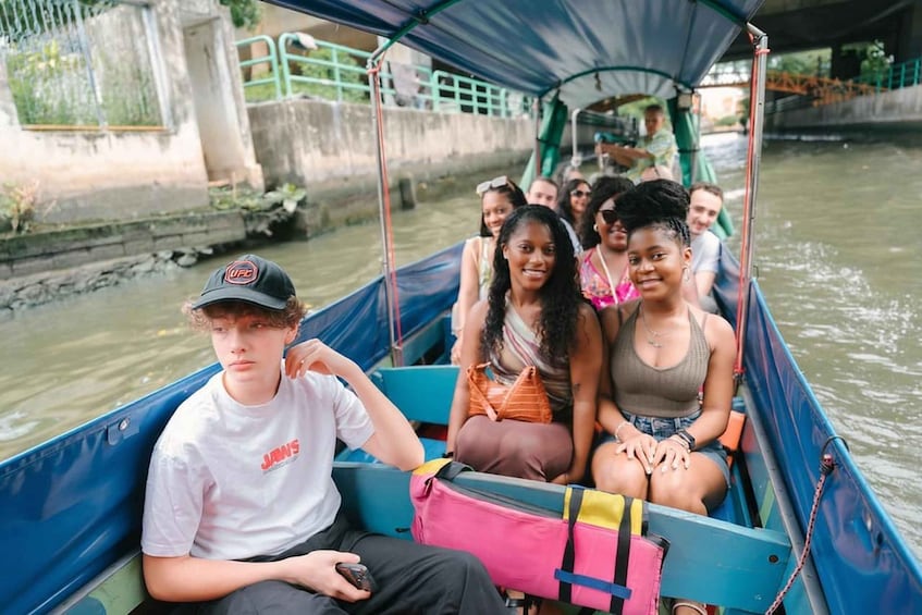 A group of people on a boat with a bridge in the background. 4