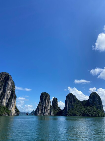 A calm sea with tall limestone cliffs and a clear blue sky. 5