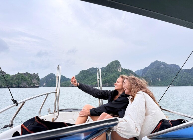 Two people on a boat with a mountainous landscape in the background. 4