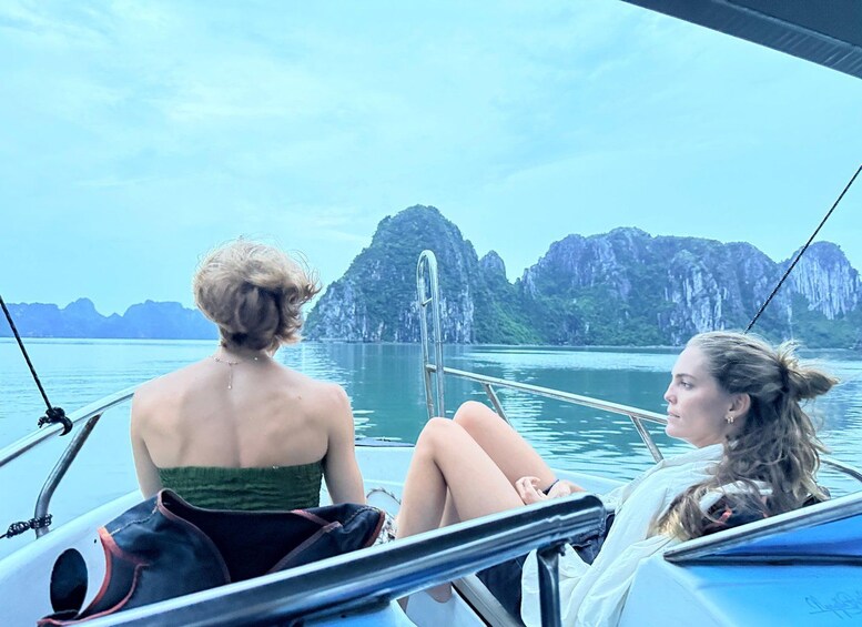 Two people on a boat with a mountainous landscape in the background. 3