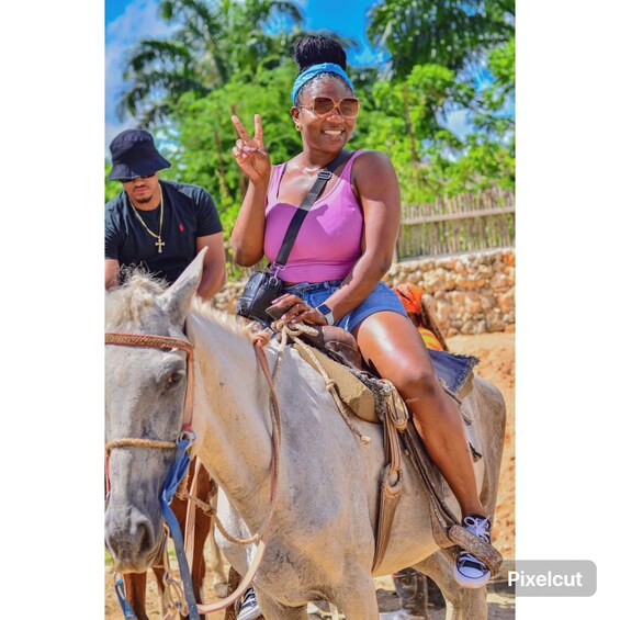 A person riding a donkey in a rural setting with greenery in the background. 3