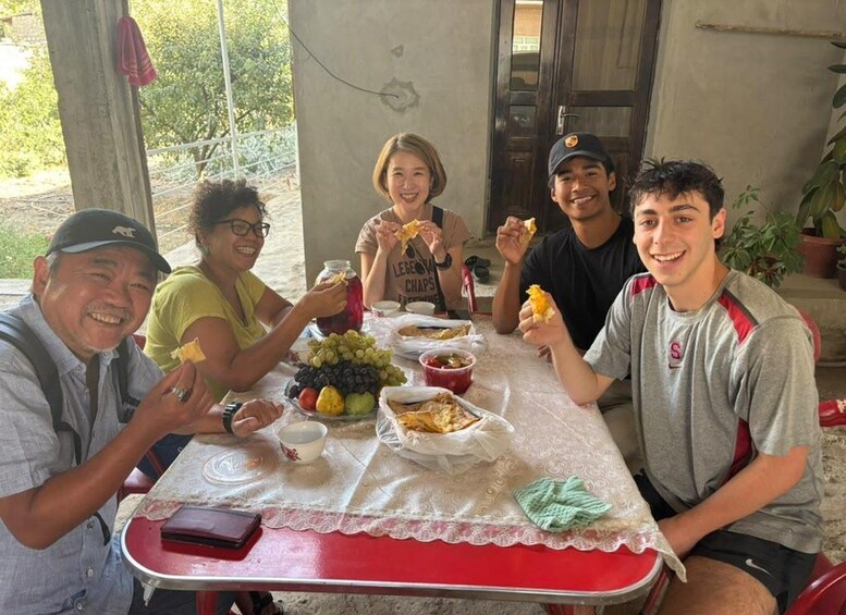 A group of people sitting at a table with food and drinks. 2