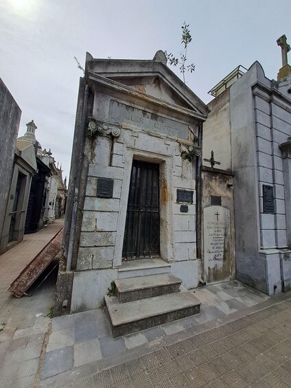 A cemetery with a weathered tombstone labeled "Luis Vernet" and a cross. 5