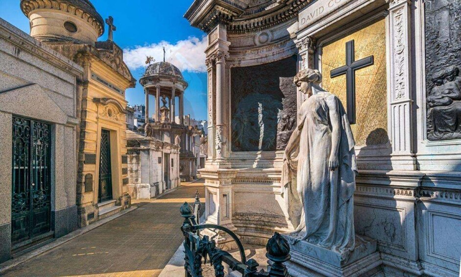 A street with ornate buildings, a statue, and a fountain. 1