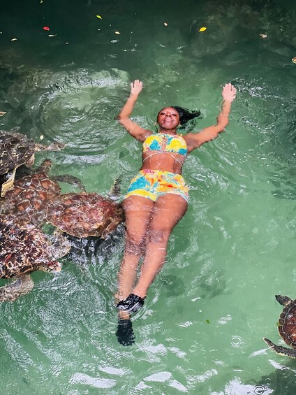 A person swimming with sea turtles in clear water. 3