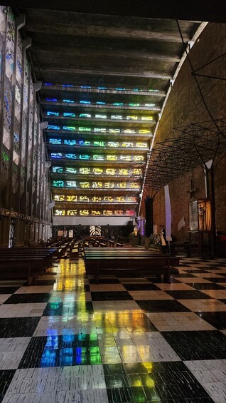A church interior with colorful stained glass windows and a checkered floor. 3