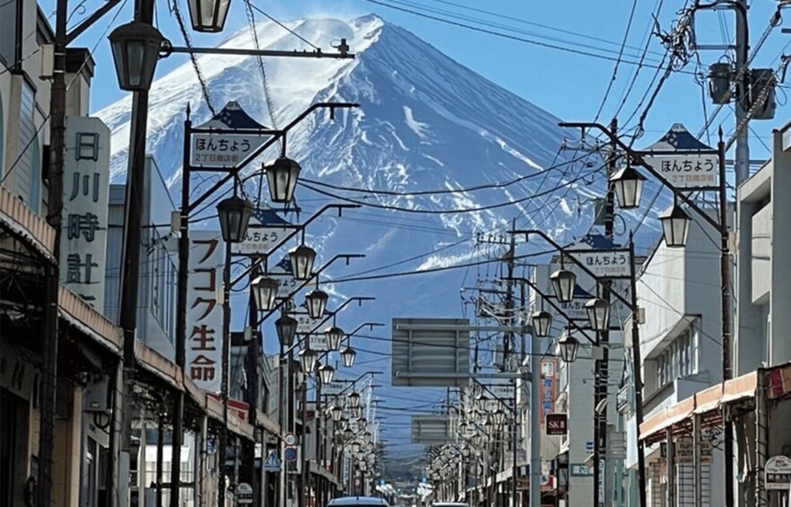 A street with street lamps and signs, a mountain in the background, and power lines overhead. 2