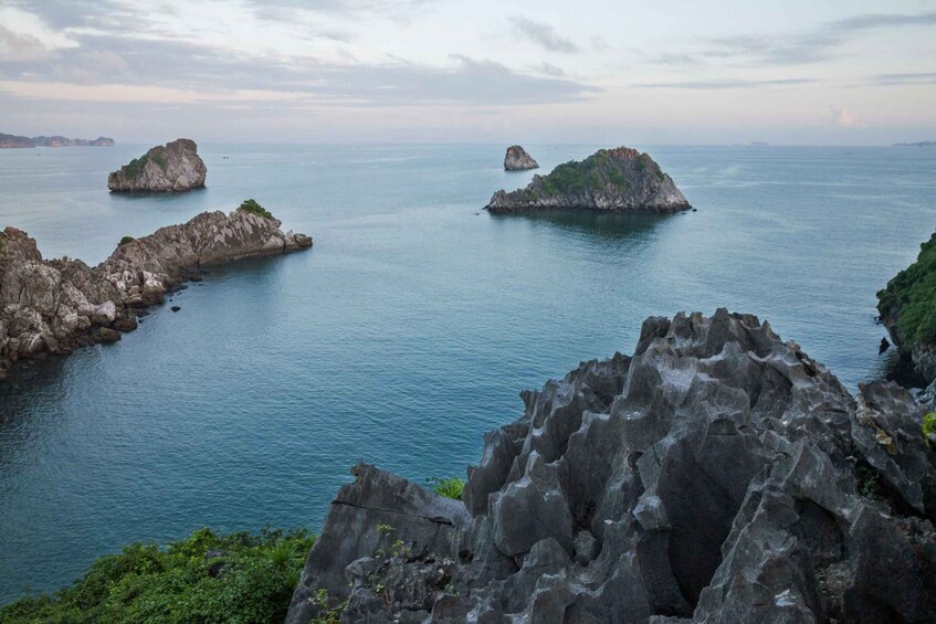 A coastal landscape with rocky outcrops and calm sea. 5