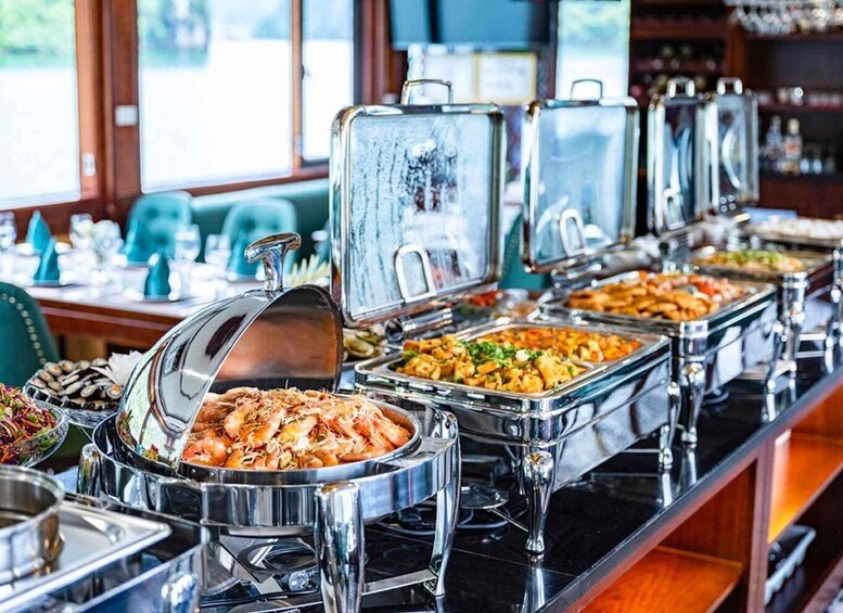 A buffet with various food items in metal containers. 4