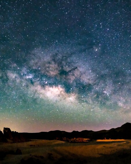 A starry night sky over a hilly landscape. 1