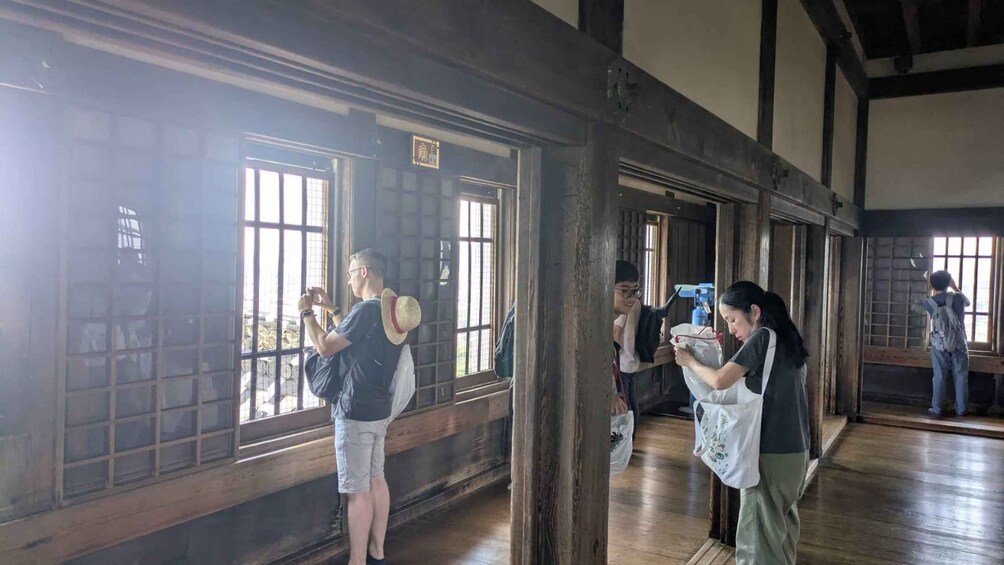 A wooden interior with large windows and people taking photos. 2