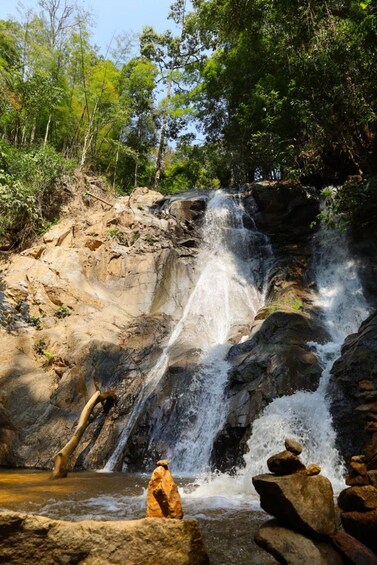 A waterfall cascading over rocks in a forested area. 2
