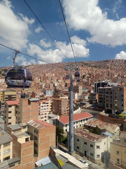A cable car system in a densely populated urban area with numerous buildings and a clear sky. 4
