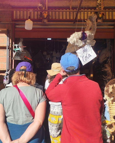 A group of people at a market stall with handmade crafts and decorations. 2