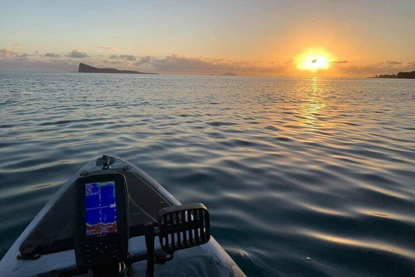 Un bote sobre aguas tranquilas con un atardecer de fondo. 3