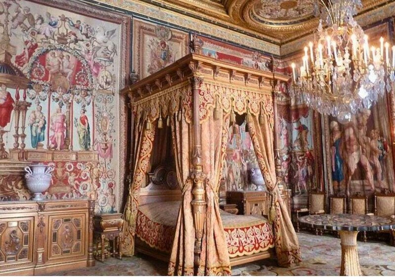 An ornate bedroom with a four-poster bed, elaborate wall paintings, and a chandelier. 5