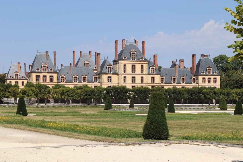 A large, historic building with multiple chimneys and a symmetrical facade. 4