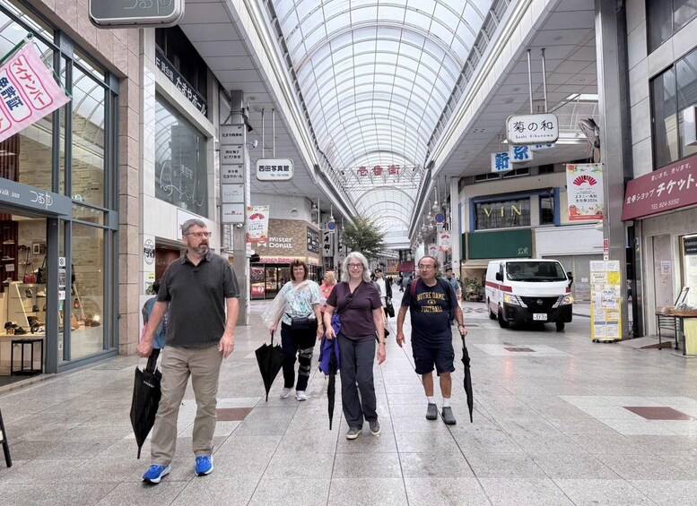 A covered pedestrian walkway with shops and signs in Japanese. 2