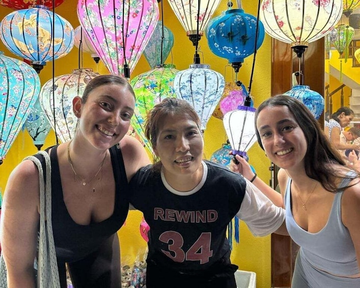 Three people in a room with colorful lanterns. 3