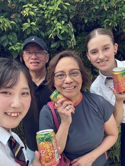 Four people outdoors with dense green foliage in the background. 2