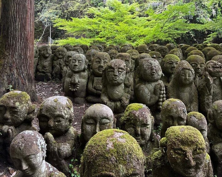 A collection of stone statues in a forested area. 3