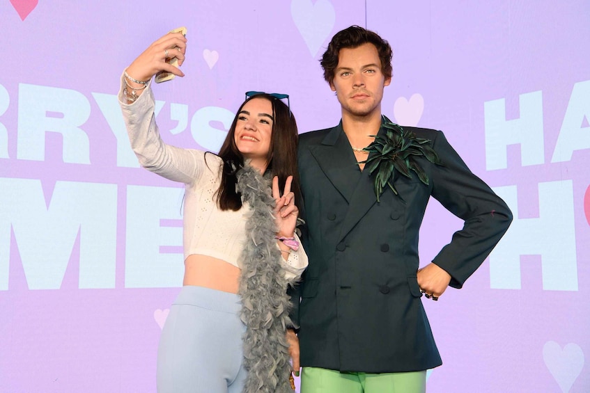 Two people posing for a photo with a backdrop that includes the text "HARRY'S HONEYMOON". 1