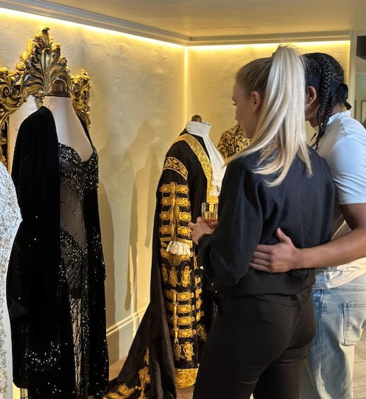 A person examining a black and gold garment on a mannequin in a store. 2