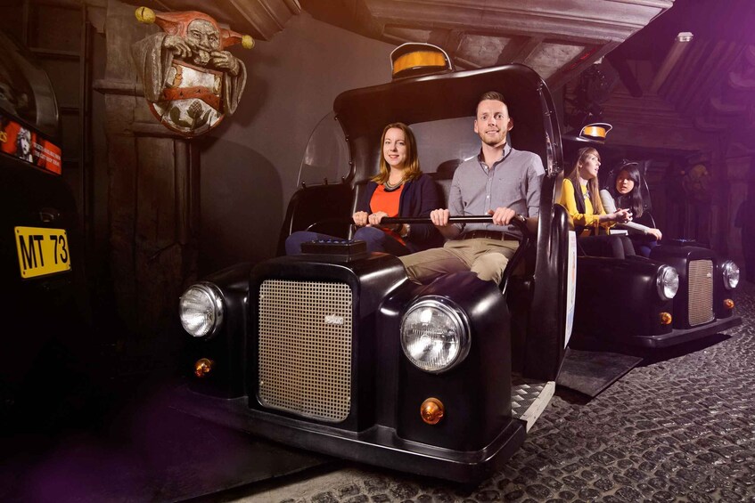 A vintage car ride in a themed setting with passengers. 4