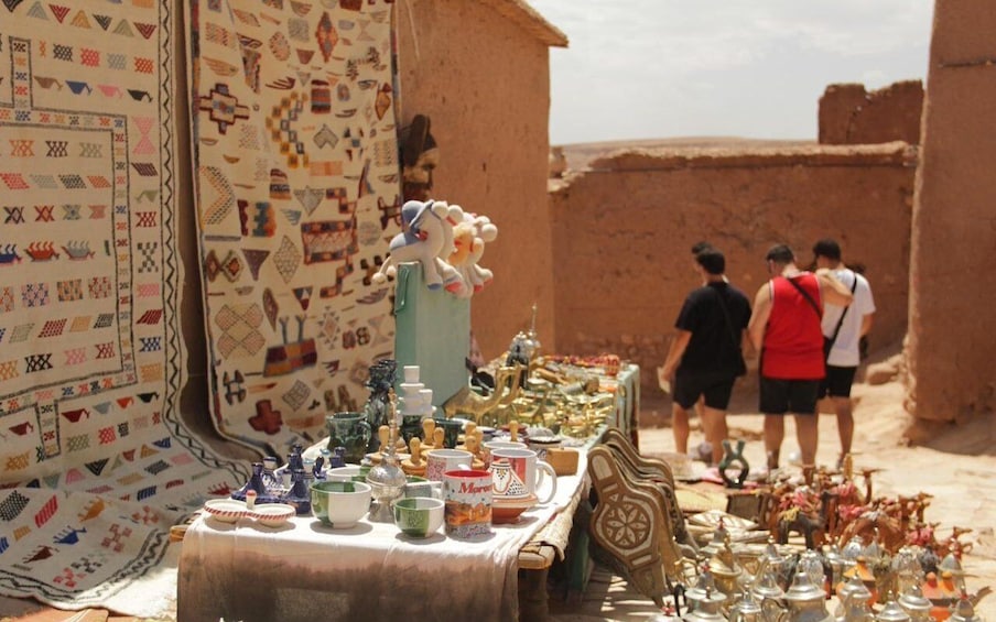 A market stall with textiles and pottery. 4