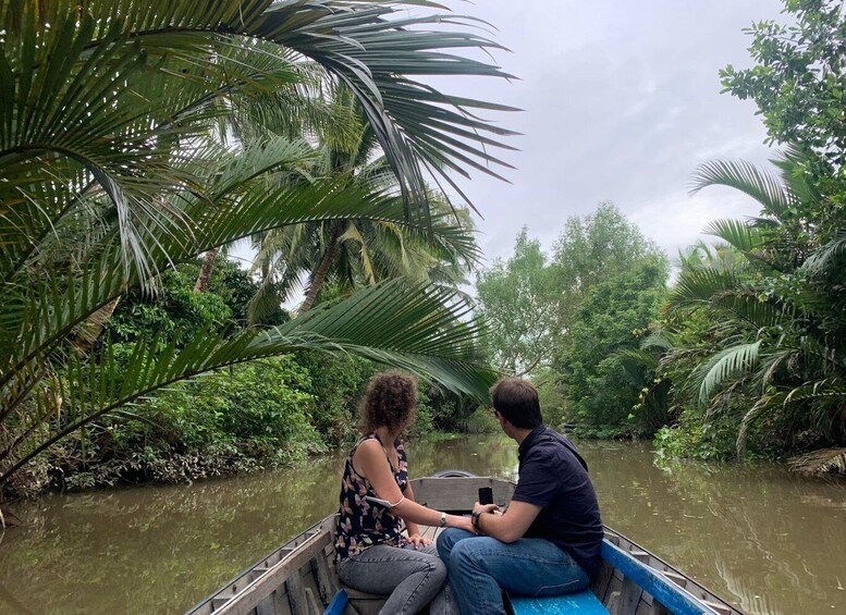 Two people in a boat on a river surrounded by dense tropical foliage. 5