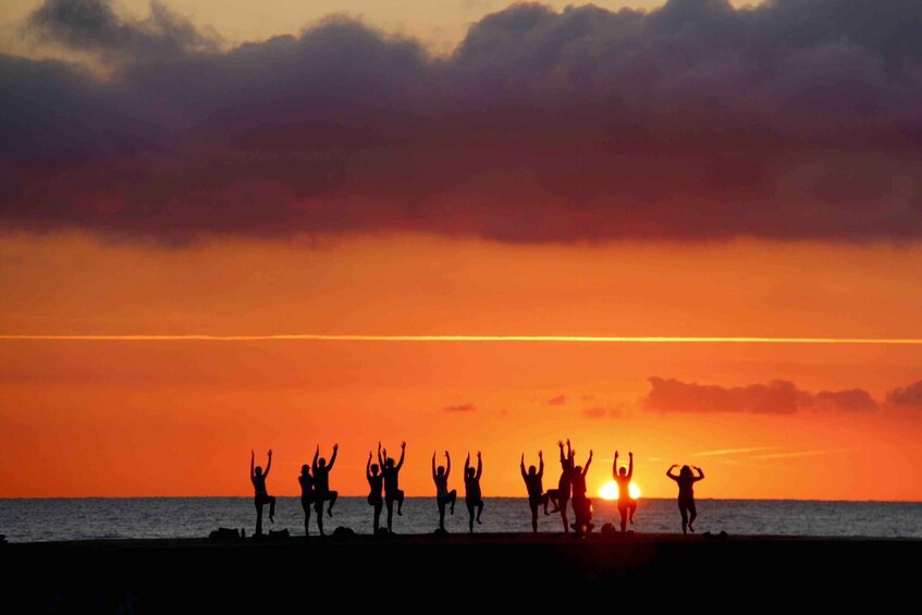 Silhouettes of people dancing on a beach at sunset. 1