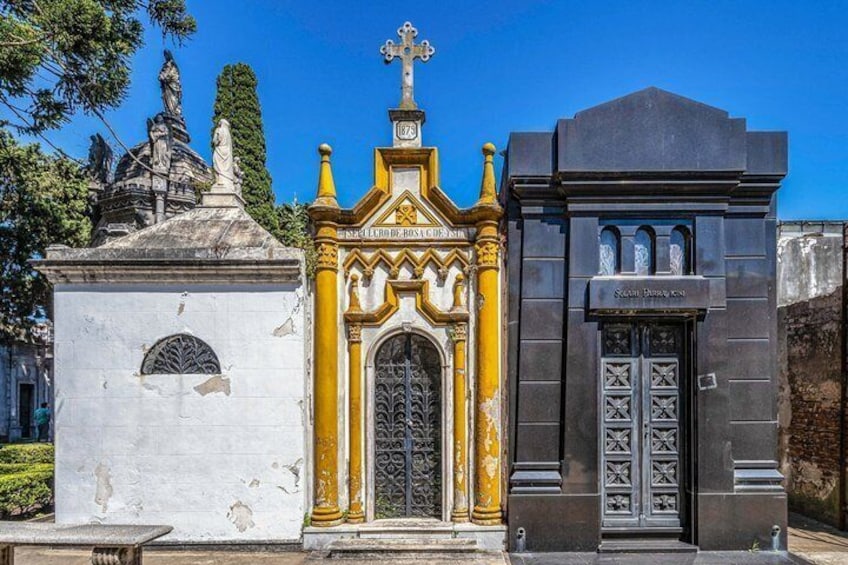 Un cimetière avec un monument blanc, une chapelle jaune et blanche, et un mausolée noir. 3
