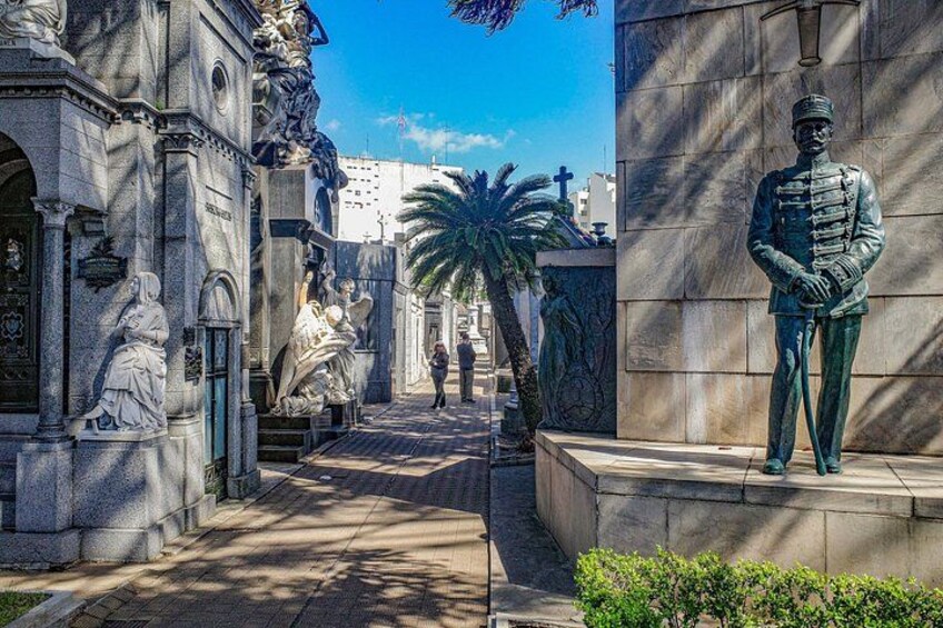 A statue of a soldier, a fountain, and classical architecture. 1
