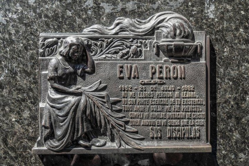 Une plaque commémorative ornée d’une sculpture représentant une femme et d’un texte. 4