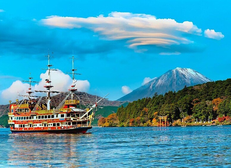 A cruise ship on a calm lake with a mountain in the background. 2