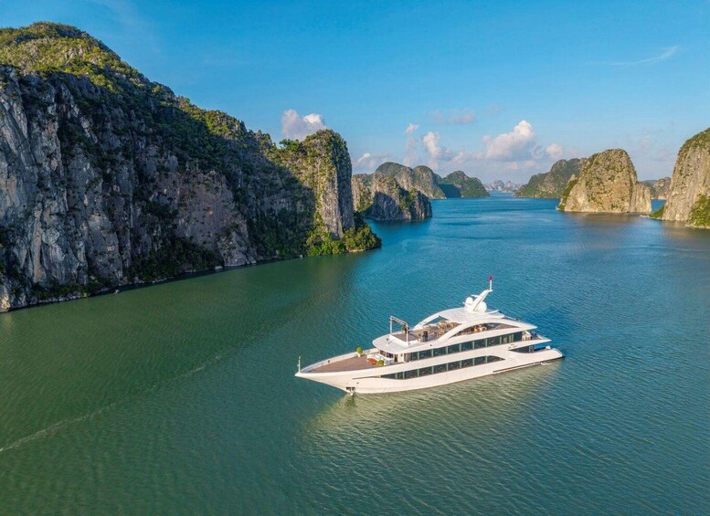 A white boat on calm waters surrounded by rocky cliffs. 3