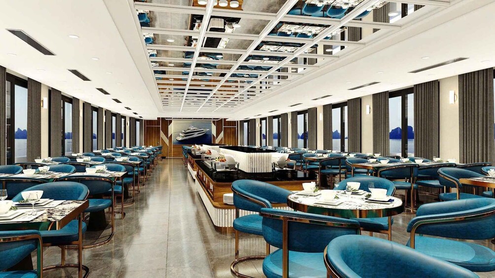 A modern dining area with blue chairs and tables, a central bar, and large windows. 5