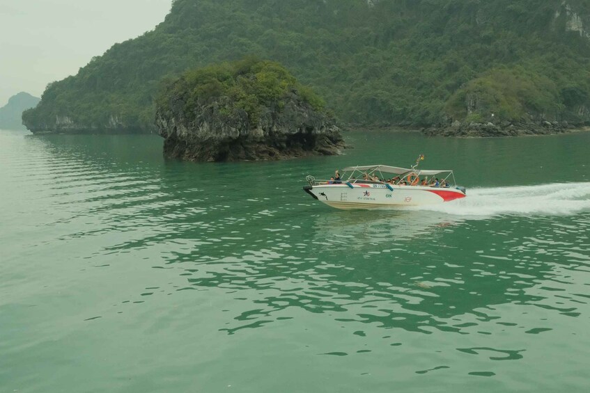 Una barca sfreccia su un fiume calmo, con un'isola rocciosa sullo sfondo. 2