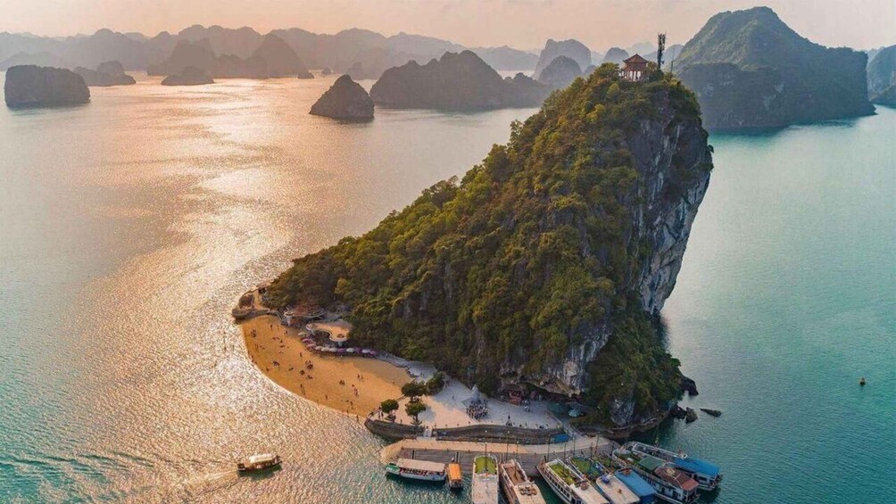 Un'isola costiera con spiaggia, imbarcazioni e un pagodo. 3