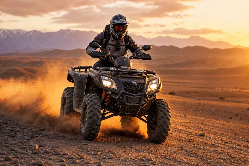 A person riding a quad bike on a dirt road with mountains in the background. 1