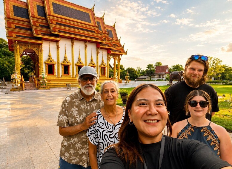 A group of people in front of a temple with ornate architecture and a statue of an elephant. 3
