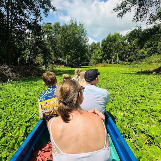 A group of people in a boat on a river surrounded by greenery. 2