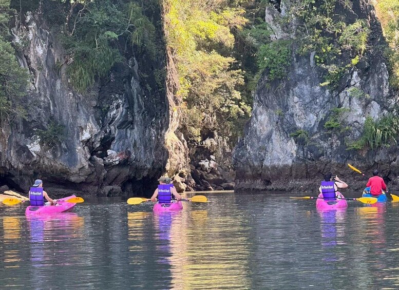 People kayaking on a river with rocky cliffs in the background. 5